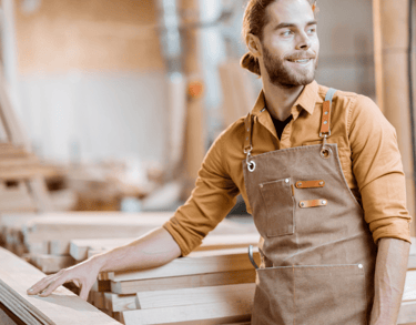 Smiling tradesman at a woodpile