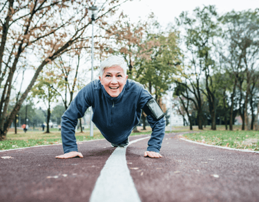 Woman with short white hair does push ups in park in Basalt, CO after acupuncture for menopause