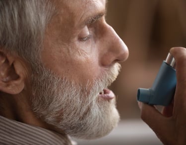 Hombre aplicándose un inhalador