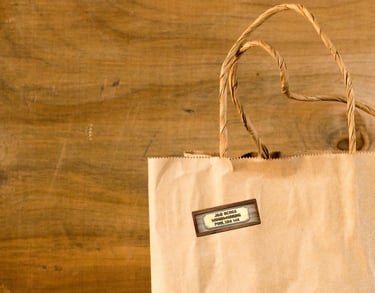 Brown paper shopping bag with J & D Ochoa Woodworking Logo sticker
