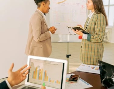 Consultant showing real-time financial metrics on laptop to client