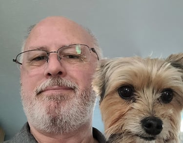 a man in a gray shirt is holding a dog