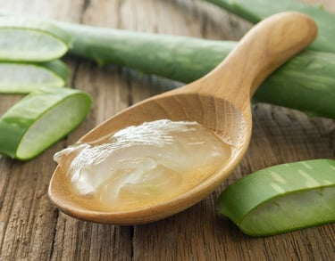 Una cucharada de aloe con una cuchara y un poco de aloe en rodajas.