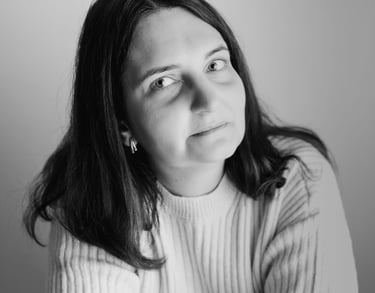 a woman with a white sweater looking towards the camera smiling