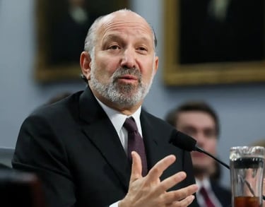 a man in a suit and tie is speaking into a microphone