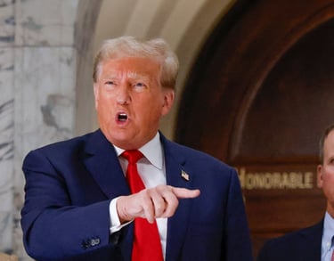 a man in a suit and tie is pointing at a microphone