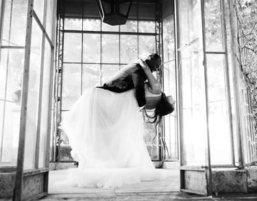 Black and white photo of elopement couple dancing in a glass greenhouse in Provence