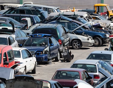A bunch of cars parked in a scrap yard