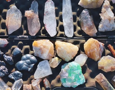 Una colección de cristales de sanación en estado natural, incluyendo puntas de cuarzo transparente