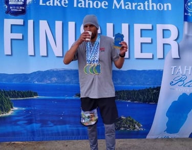 Ray Z aka Ray Z Unstoppable at the finish of the Lake Tahoe Triple Marathon with medals