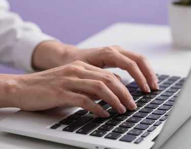 Close-up of hands typing on a modern keyboard in a clean, professional North American office environment. The surrounding space has soft lavender accents.