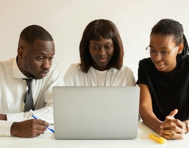 a man and woman sitting at a table with a laptop