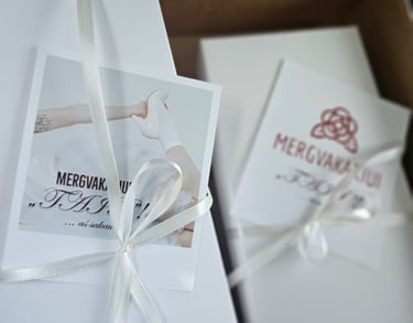 Keliaraištis supakuotas į baltą dovanų dėžutę; pat pridėtas atvirukas su sveikinimu nuotakai.