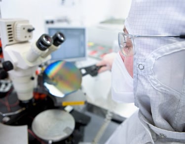 optical stereo microscope image with a cleanroom engineer inspecting a silicon wafer