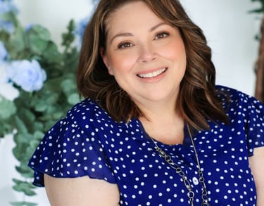 a woman in a blue dress smiling and holding a flower