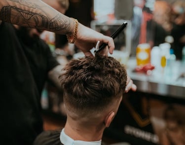 a man getting his hair cut in a barbershop