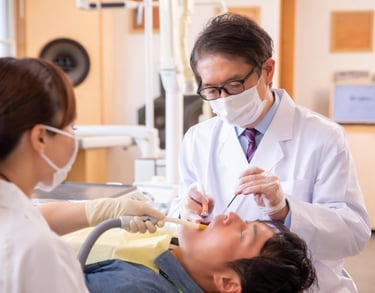 An image of a dentist, dentist assistant, and a patient.