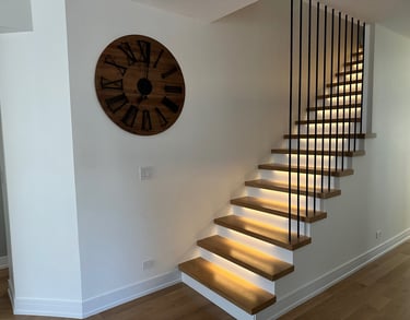 Modern floating oak staircase renovation with LED under-lighting and custom black metal railings