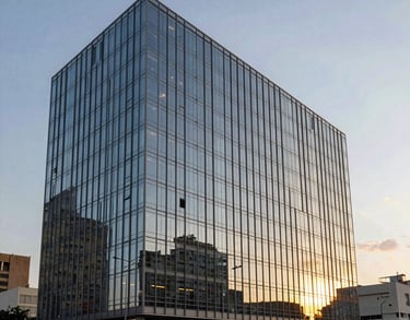 Exterior of a modern glass office building in a green urban area of Brazil, sunset reflecting on the glass, clean and professional architectural photography.
