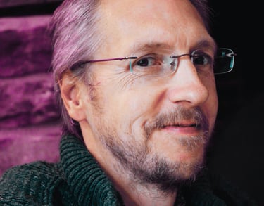 Man smiling, wearing rimless eyeglasses