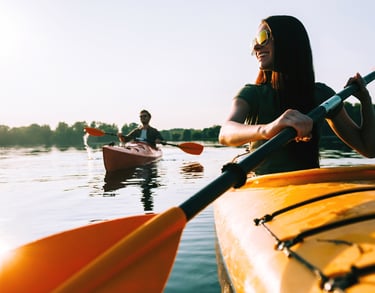 Friends kayaking and smiling with protective sunglasses