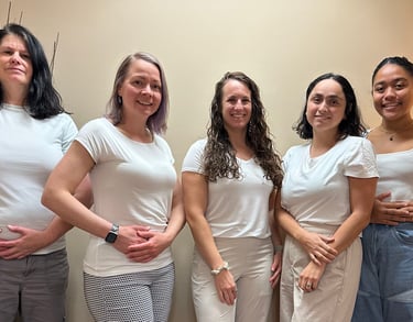 5 women standing in front of a wall