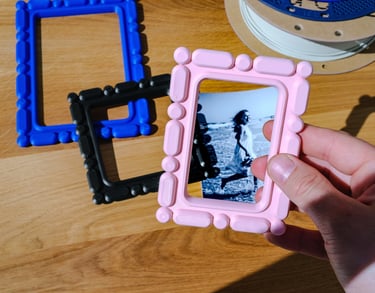 3D printed home decor frame being placed over a photo by hand, customizable personal display object