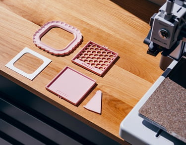 3D printed home decor parts on wooden table next to 3D printer, easy print design