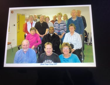 A diverse local community prayer group posing for a group portrait indoors in 2001.