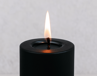 Close-up of clean-burning black pillar candle flame, designed for long-lasting ritual use.