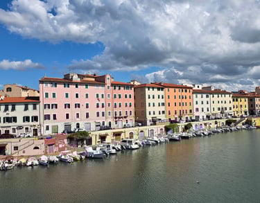 a river with boats and buildings in the background