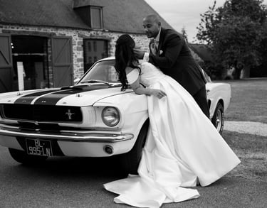 Deux mariés posant sur une ford mustang
