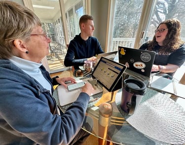 a woman sitting at a table with a man and a woman