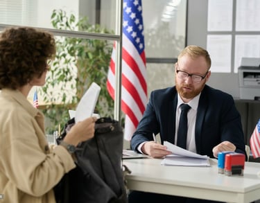 Consultant and client reviewing documents for a visit visa application, with American flags in the b