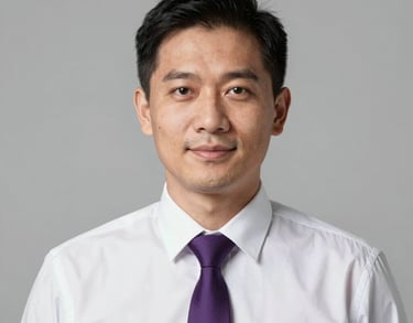 Professional studio portrait of a Southeast Asian man in a white formal shirt and purple tie, looking professional and friendly. Neutral light grey background.