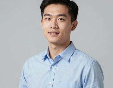 Professional studio portrait of a young Southeast Asian male consultant in a light blue shirt, looking energetic and skilled. Neutral light grey background.