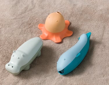 Three bath toys - blue whale, orange octopus and grey hippopotamus