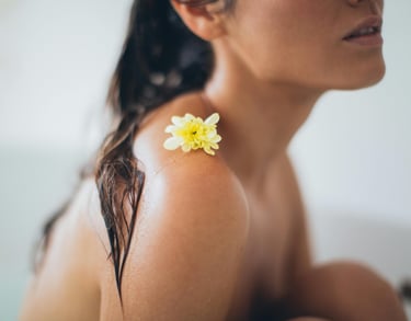 Vrouw met bloem op haar schouder 