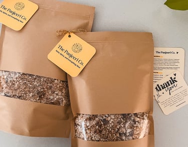 Two sealed, recyclable brown paper bags filled with handcrafted subcontinental granola (Panjeeri).