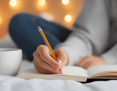 cup of coffee next to journal and pencil