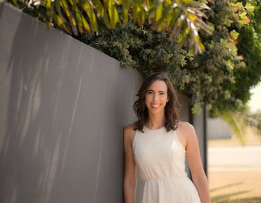 a woman in a white dress standing next to a wall