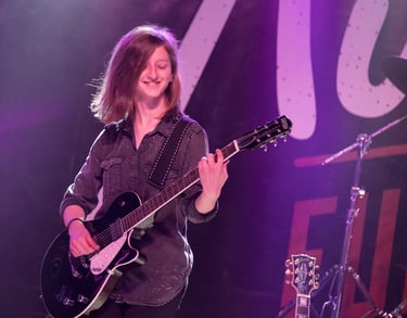 Seattle Guitar Academy a woman in a black shirt playing guitar