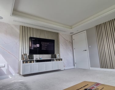 Bespoke wood slat acoustic panelling with integrated LED backlighting around a flush-mounted TV