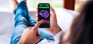 a person laying on a bed with a cell phone
