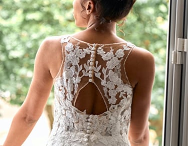 A woman in a wedding dress standing in front of a window