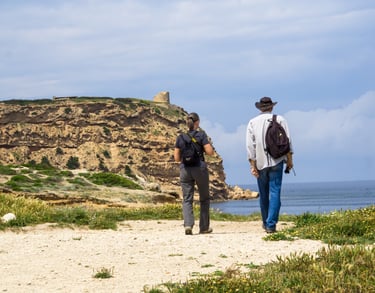 Two tourists walking to Capo Mannu tower, Sinis Peninsula Sardinia