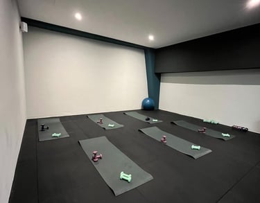 Sala fitness della palestra Move 2 Grow a Milano con tappetini, manubri e attrezzature per allenamenti di gruppo.