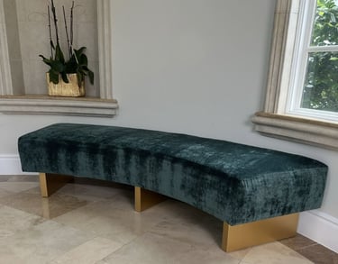 Custom curved bench with emerald green velvet upholstery and gold-painted wooden legs, handcrafted by Solo Home Decor.