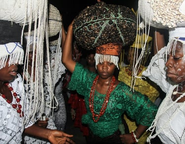 a woman in a green dress with a large basket on her head