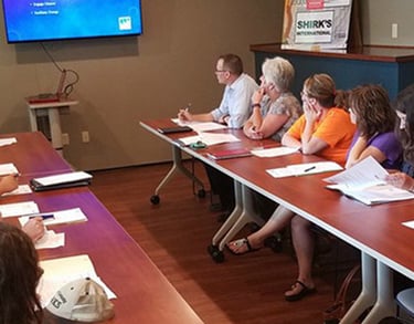a man in a suit and tie is standing in front of a group of people